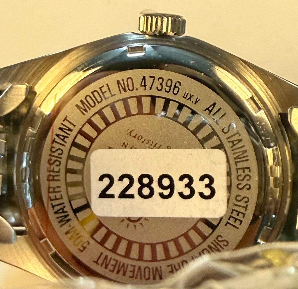 Close-up of a watch case with model number 47396 and serial number 228933.