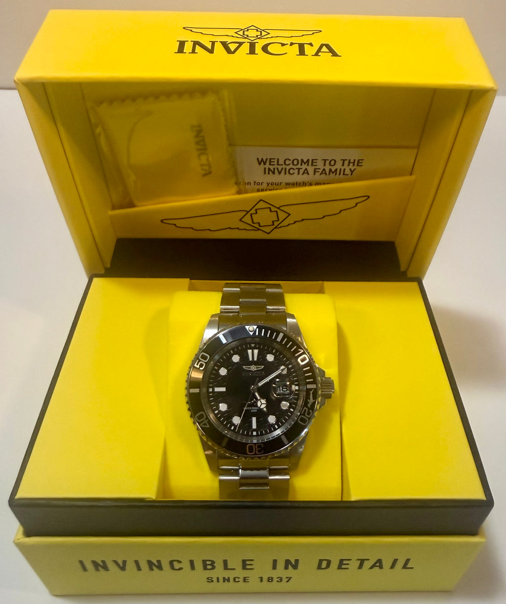 Invicta watch in a yellow box with 'Invicta' branding.