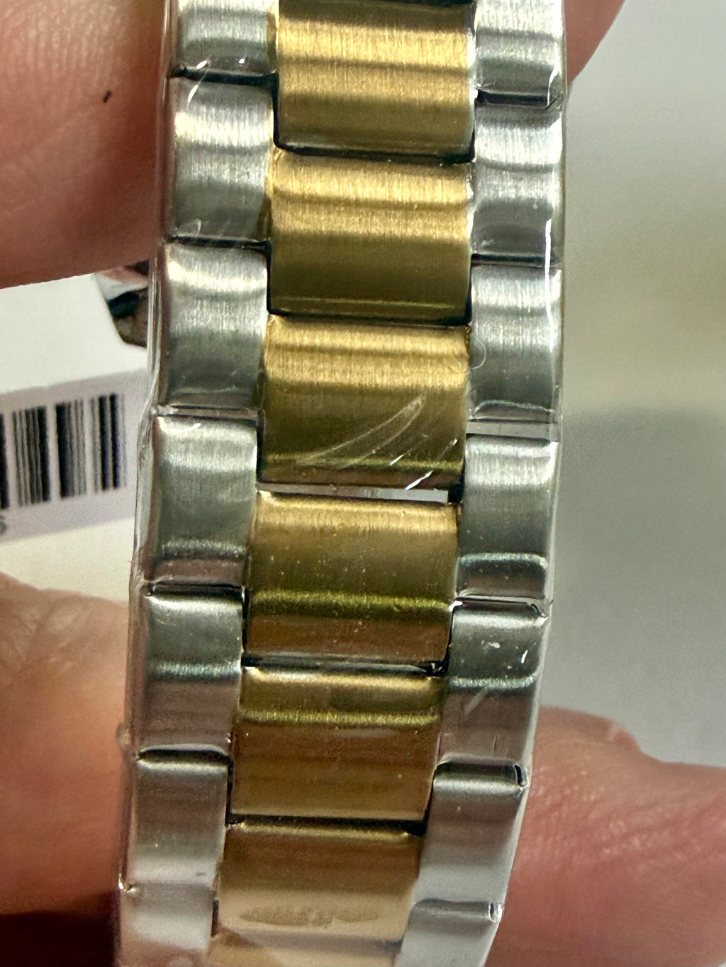 Close-up of a Invicta Specialty I Mens 42mm silver and gold watch band on a wrist.