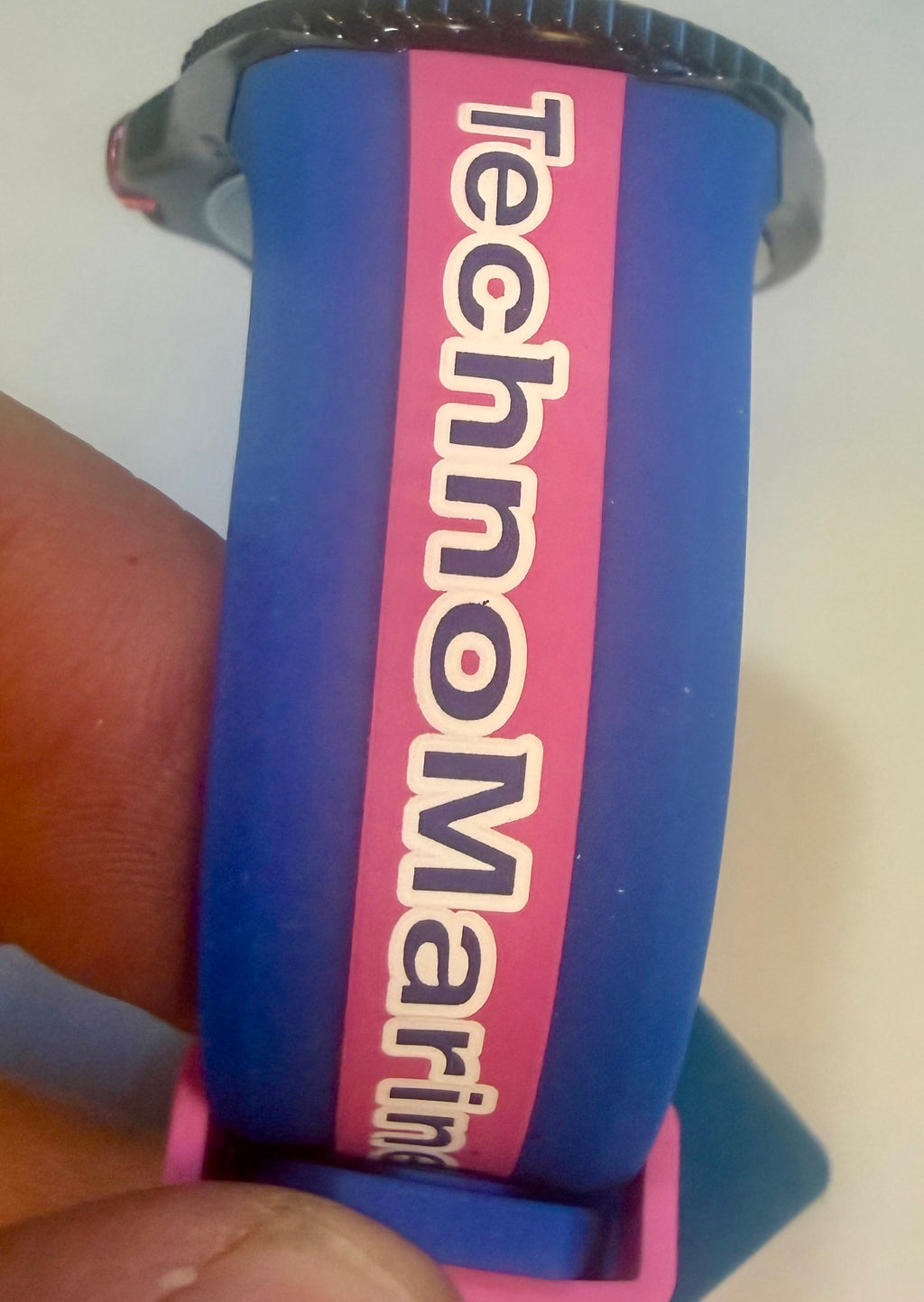 Blue and pink Techno Marine Racing Legends 44mm Wristwatch  with 'TechnoMarine' branding held by a hand.