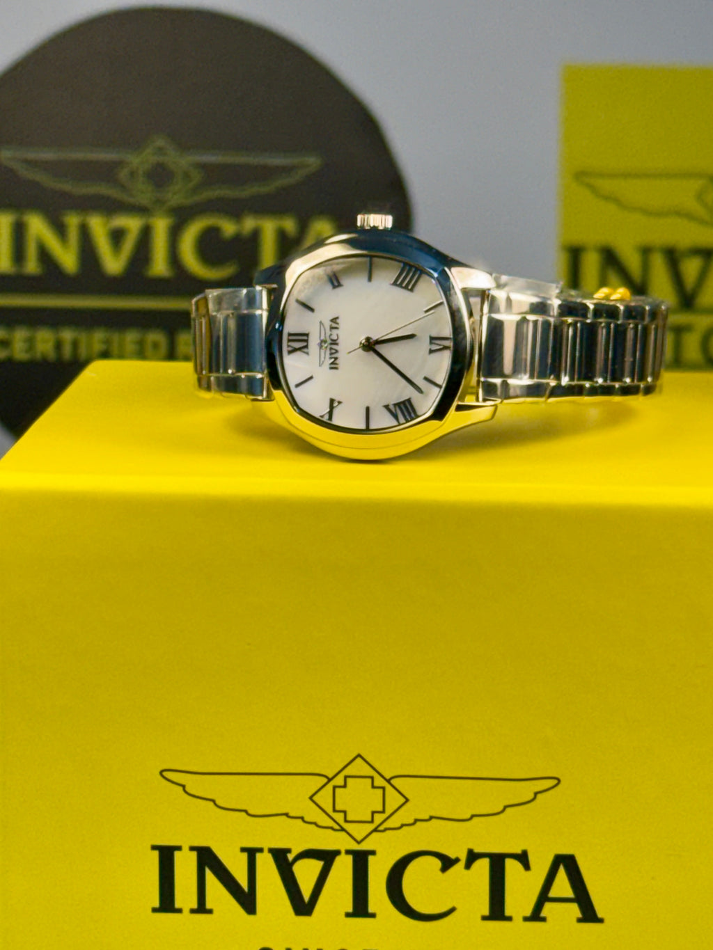 Invicta Ladies Wildflower watch on a yellow box with Invicta logo
