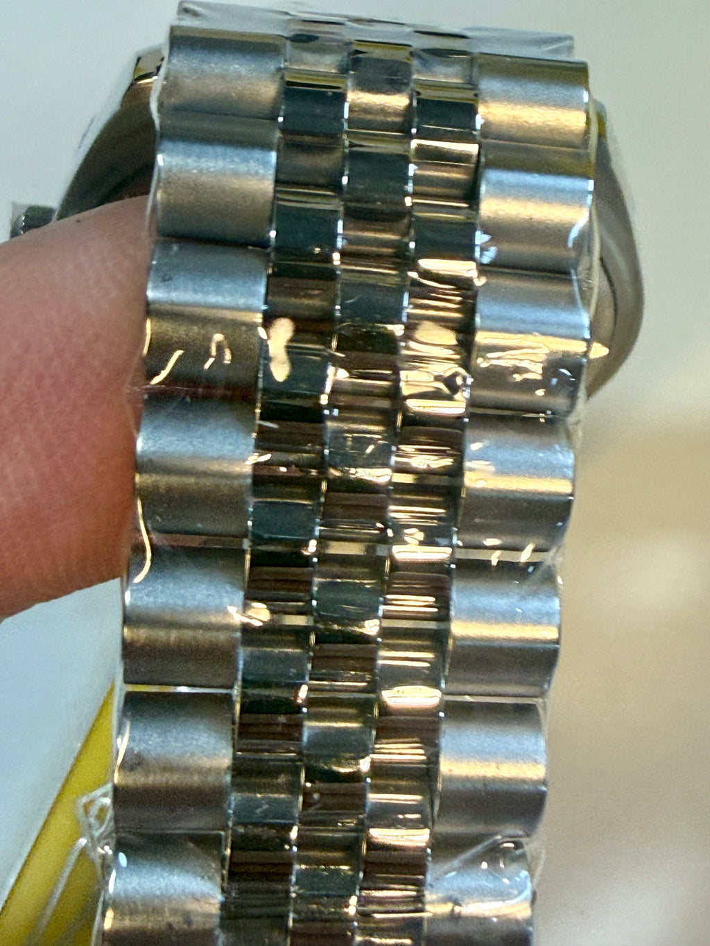 Close-up of a Invicta Specialty Windsor 43mm watch with a detailed metal band on a wrist.
