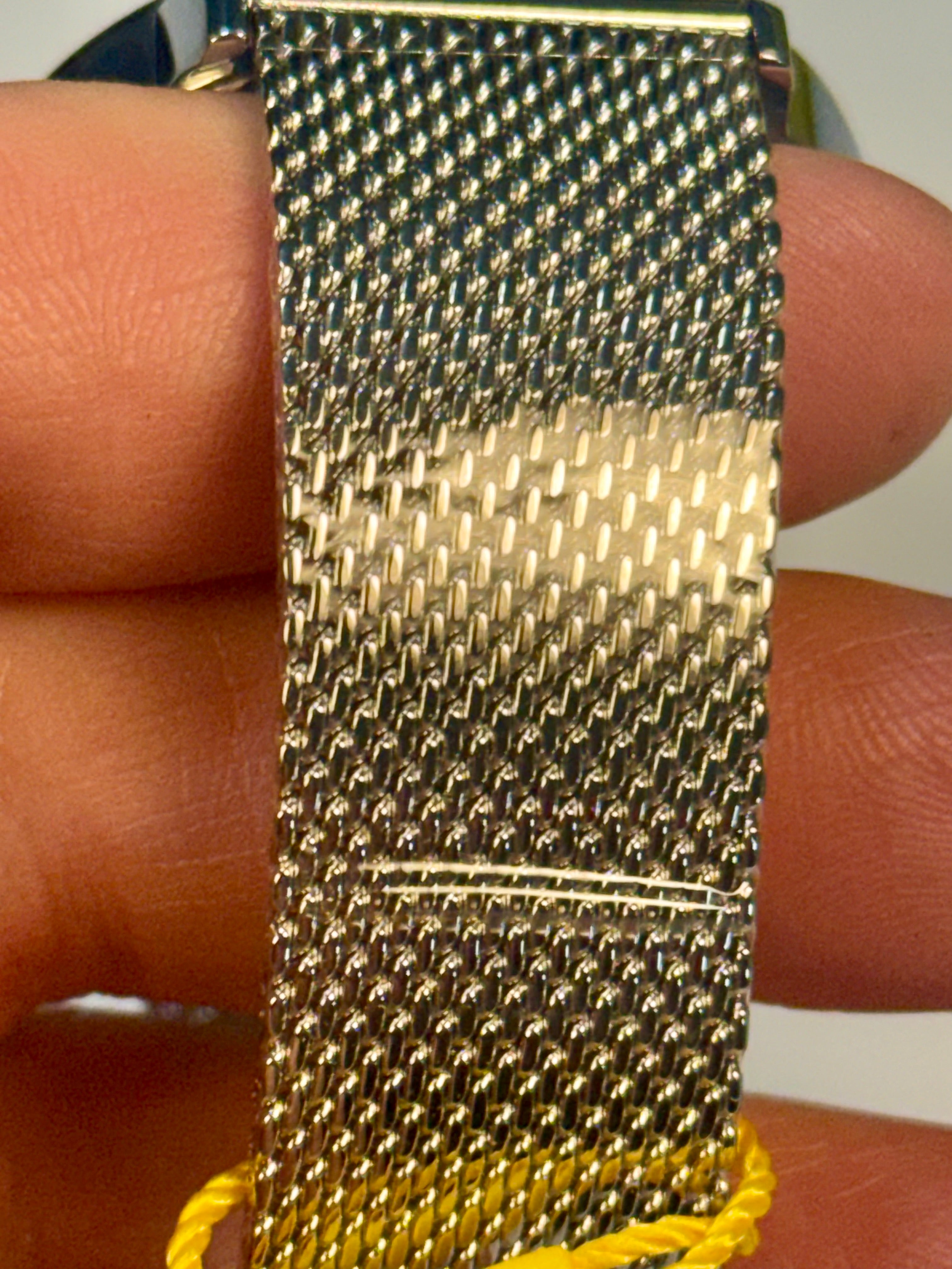 Invicta Mens Specialty mesh watch band held between fingers