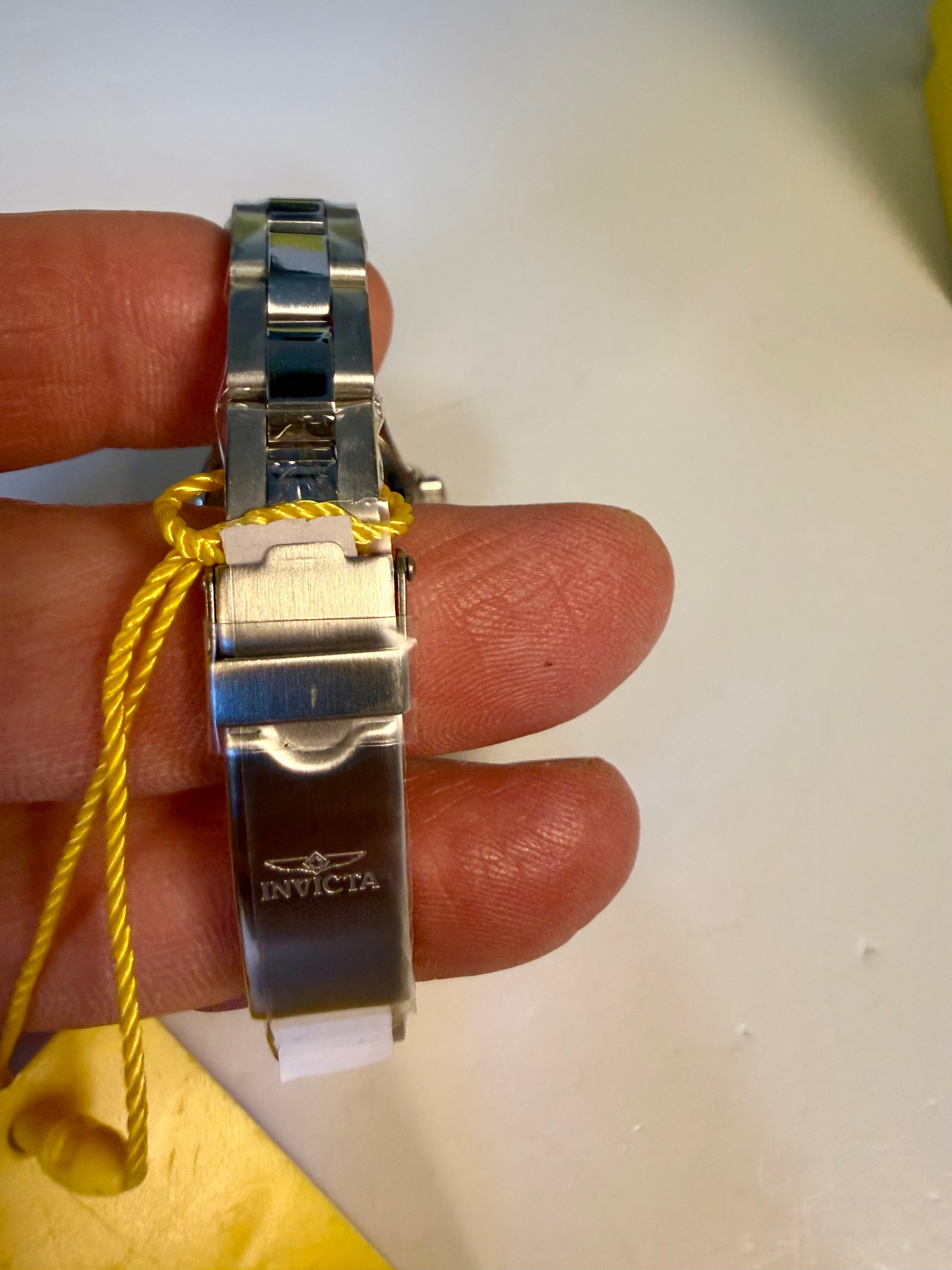 Close-up of a Ladies Pro Diver silver Invicta watch band on a finger with a white background