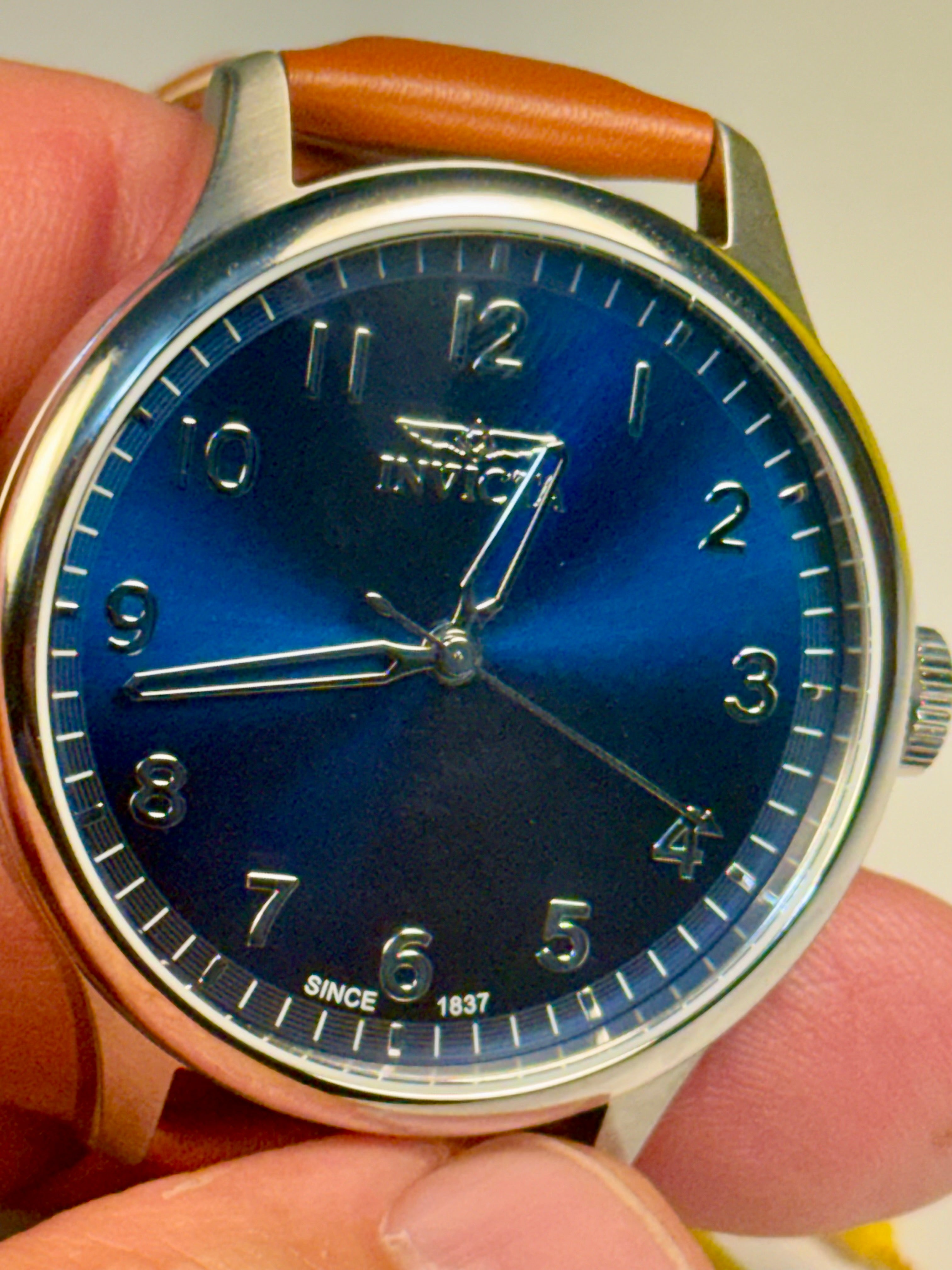 Mens Celestial Blue Sunray Dial Invicta watch with blue face held in a hand