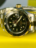 Ladies Invicta Pro Diver 24.5 mm Gold and silver watch with black face on a yellow background
