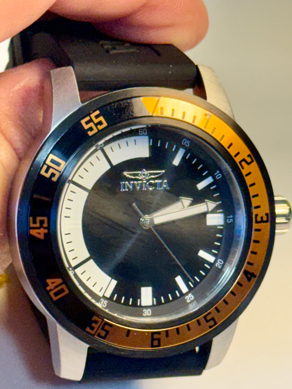 Invicta Specialty Compass with black and orange accents held in a hand