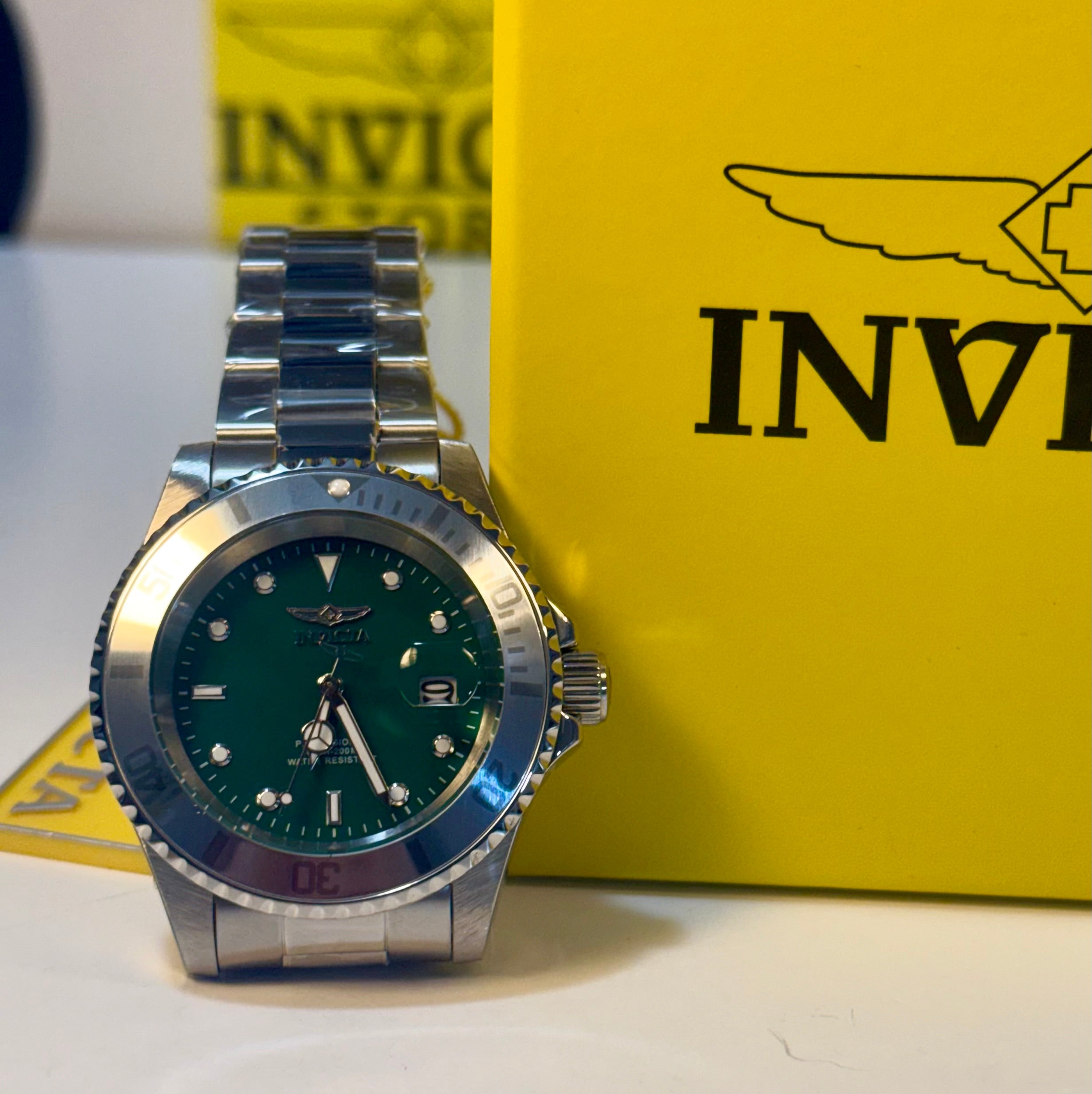 Invicta Mens Pro diver Aurenova 40mm Silver watch with green face on a yellow Invicta box