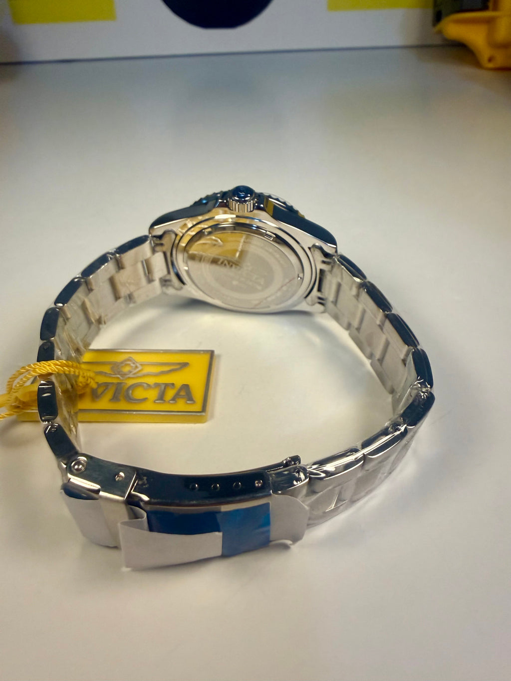 Invicta Specialty Rowan Watch with blue and silver band on a white surface, Victa brand visible