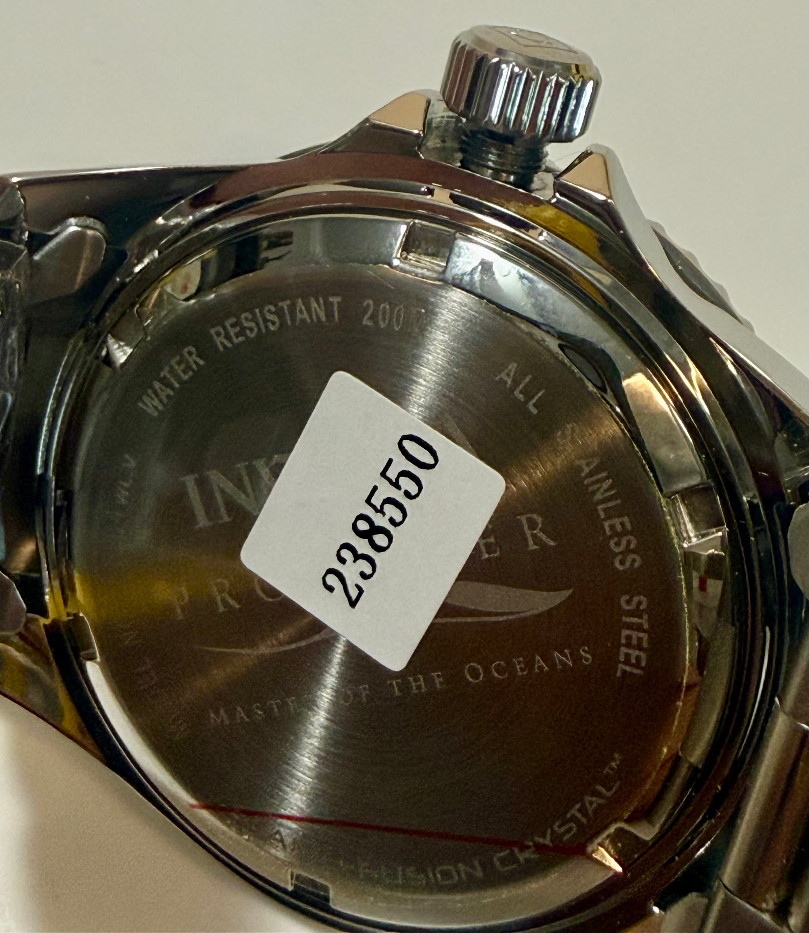 Back of a watch with a visible serial number tag on a white background