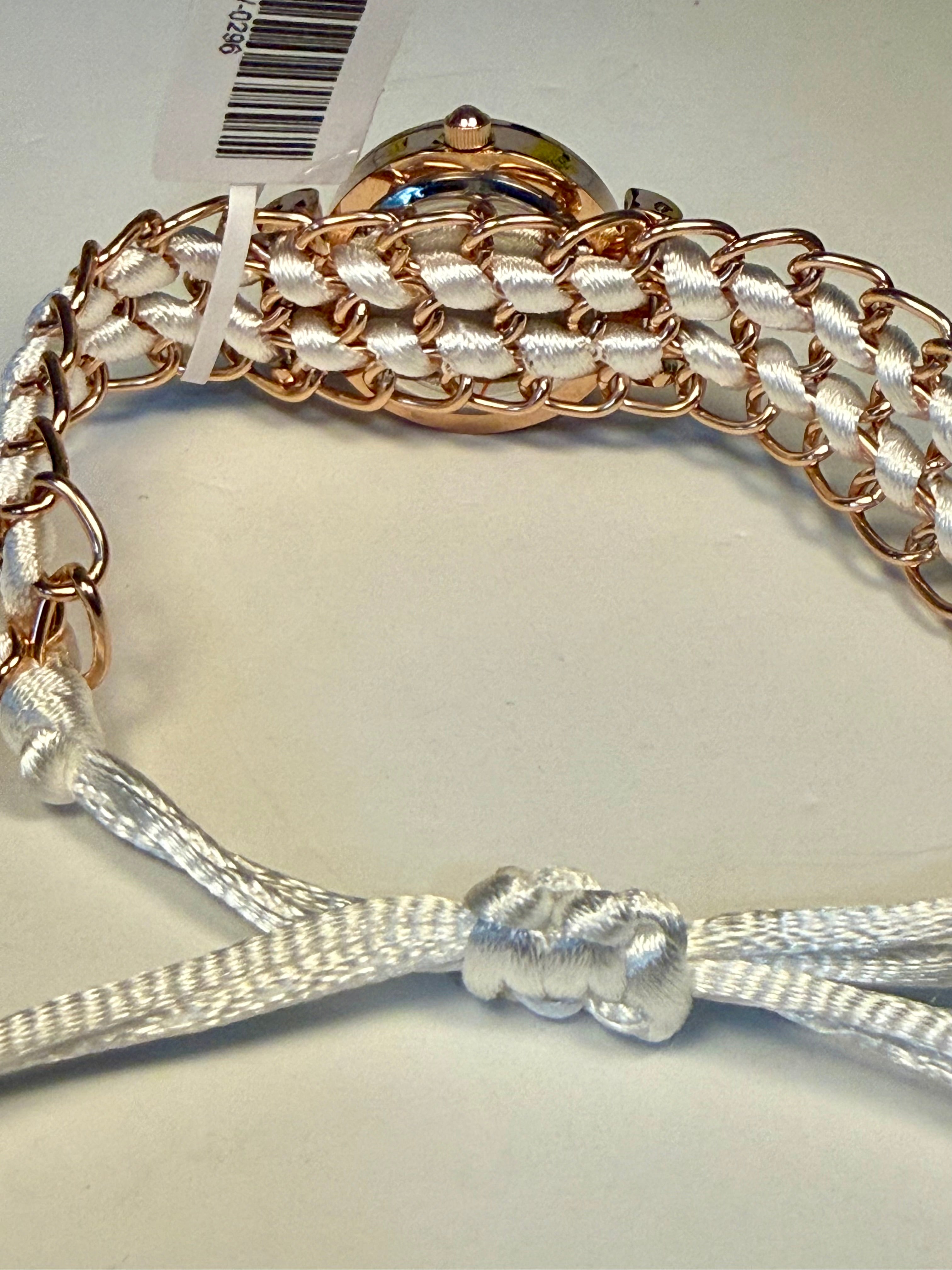 Close-up of a braided Ladies Montres Prestige bracelet with rose gold and silver accents on a white background.