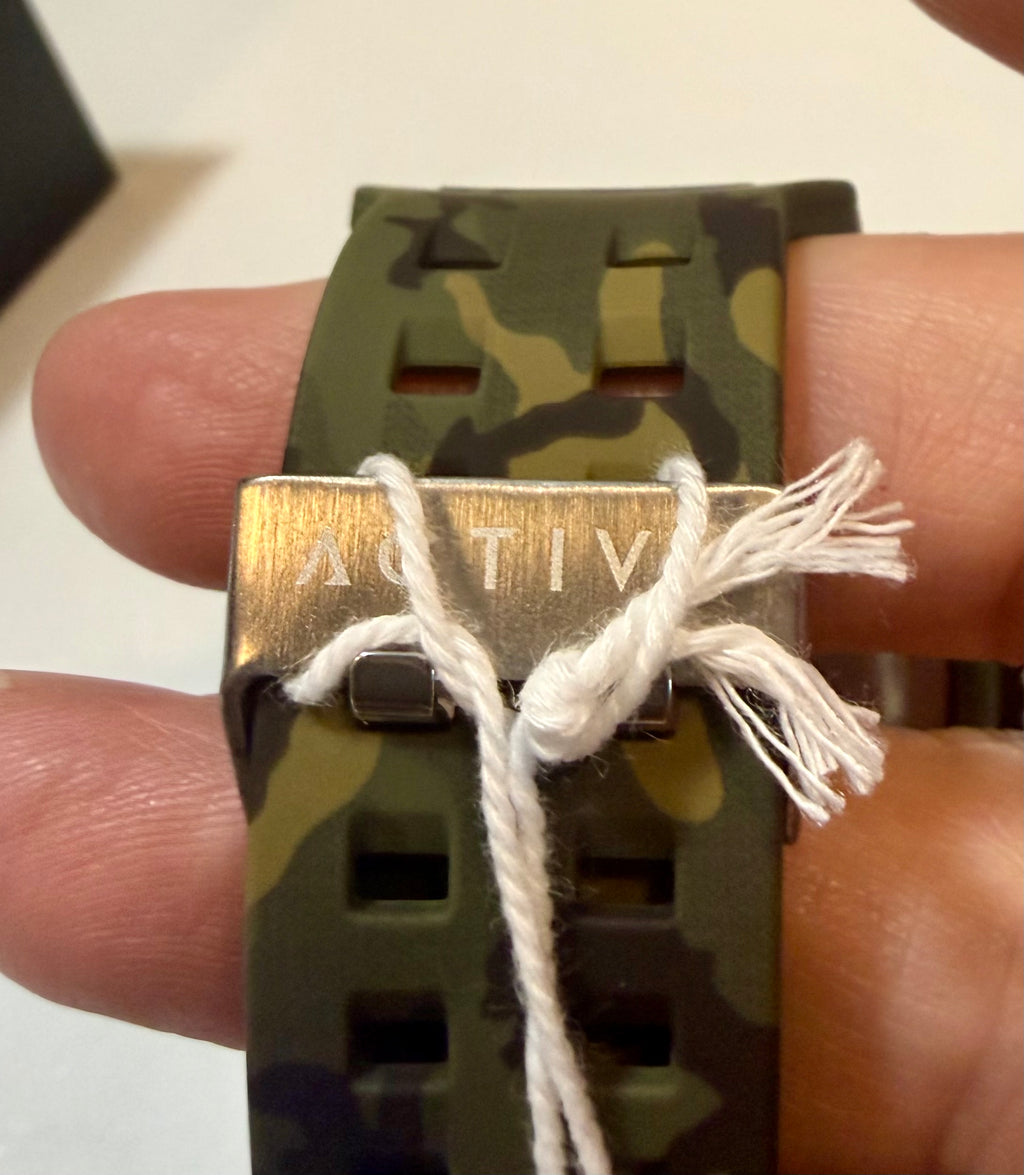 Activa X Black Ops 52mm Camouflage digital watch, held between fingers.