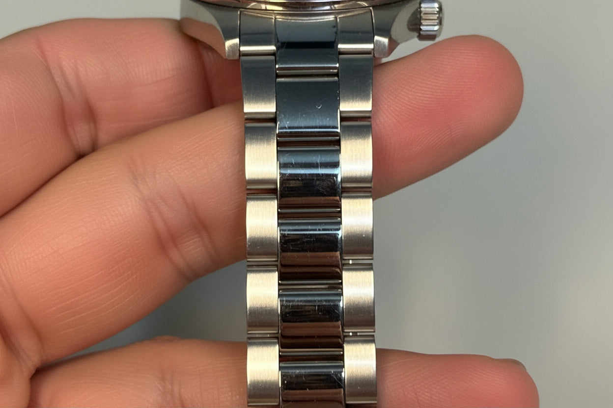 Invicta Pro Diver 12819 Swiss Ronda 515 40mm 0.06ctw DiamondSilver watch band held between fingers with a blurred background