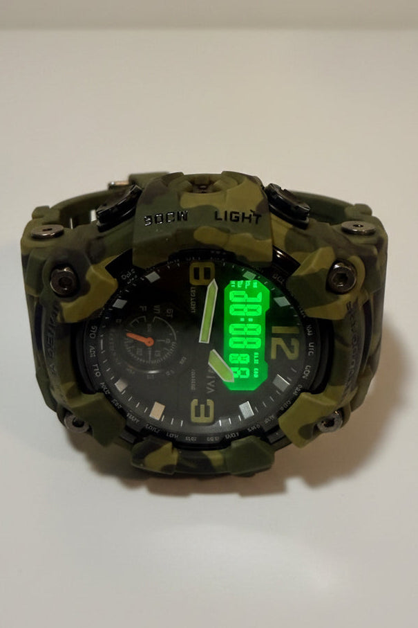 Activa X Black Ops 52mmCamouflage-patterned mechanical device with a green digital display on a white background