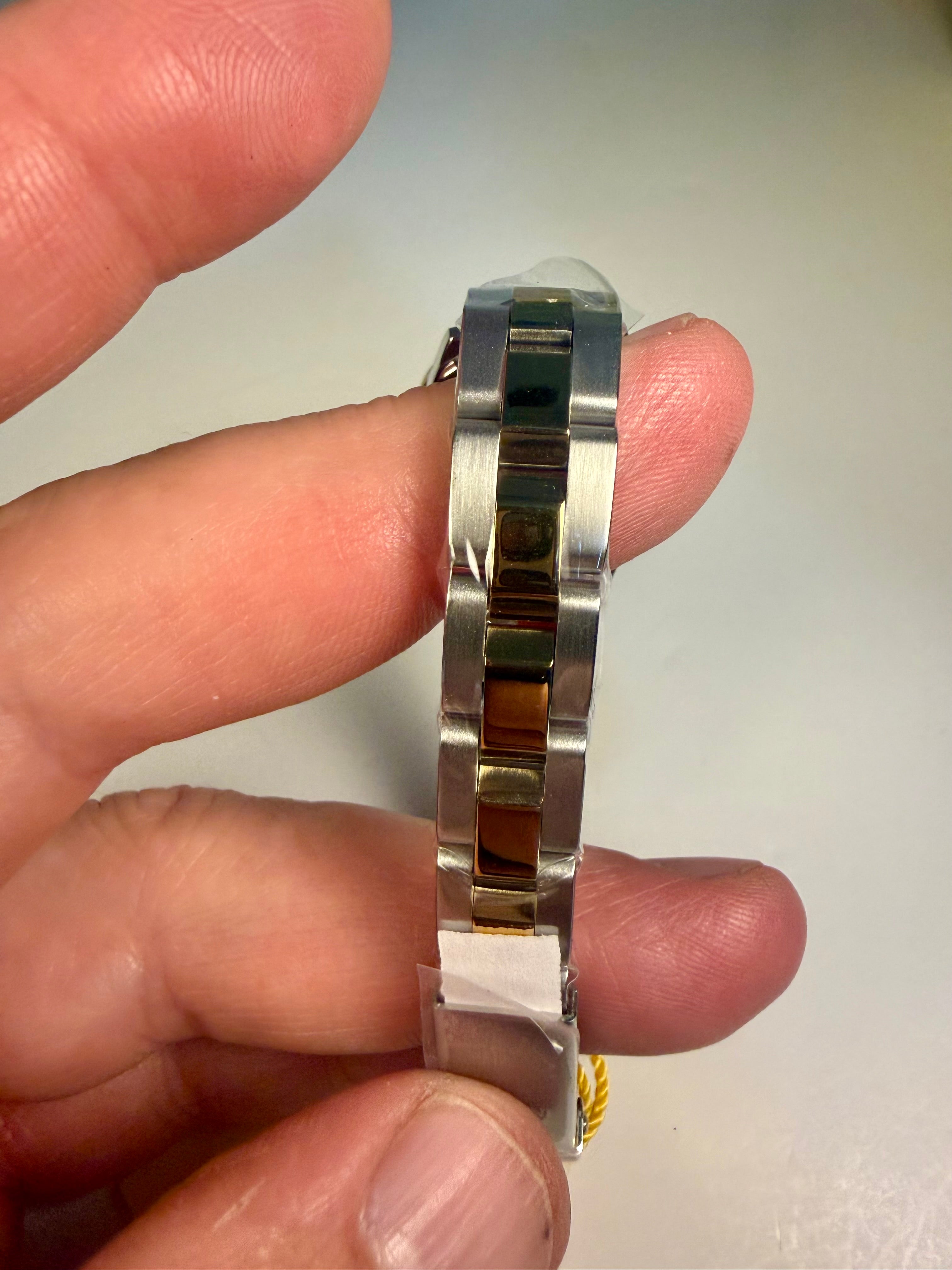 Silver Ladies Invicta Pro Diver 24.5 mm held between fingers against a neutral background
