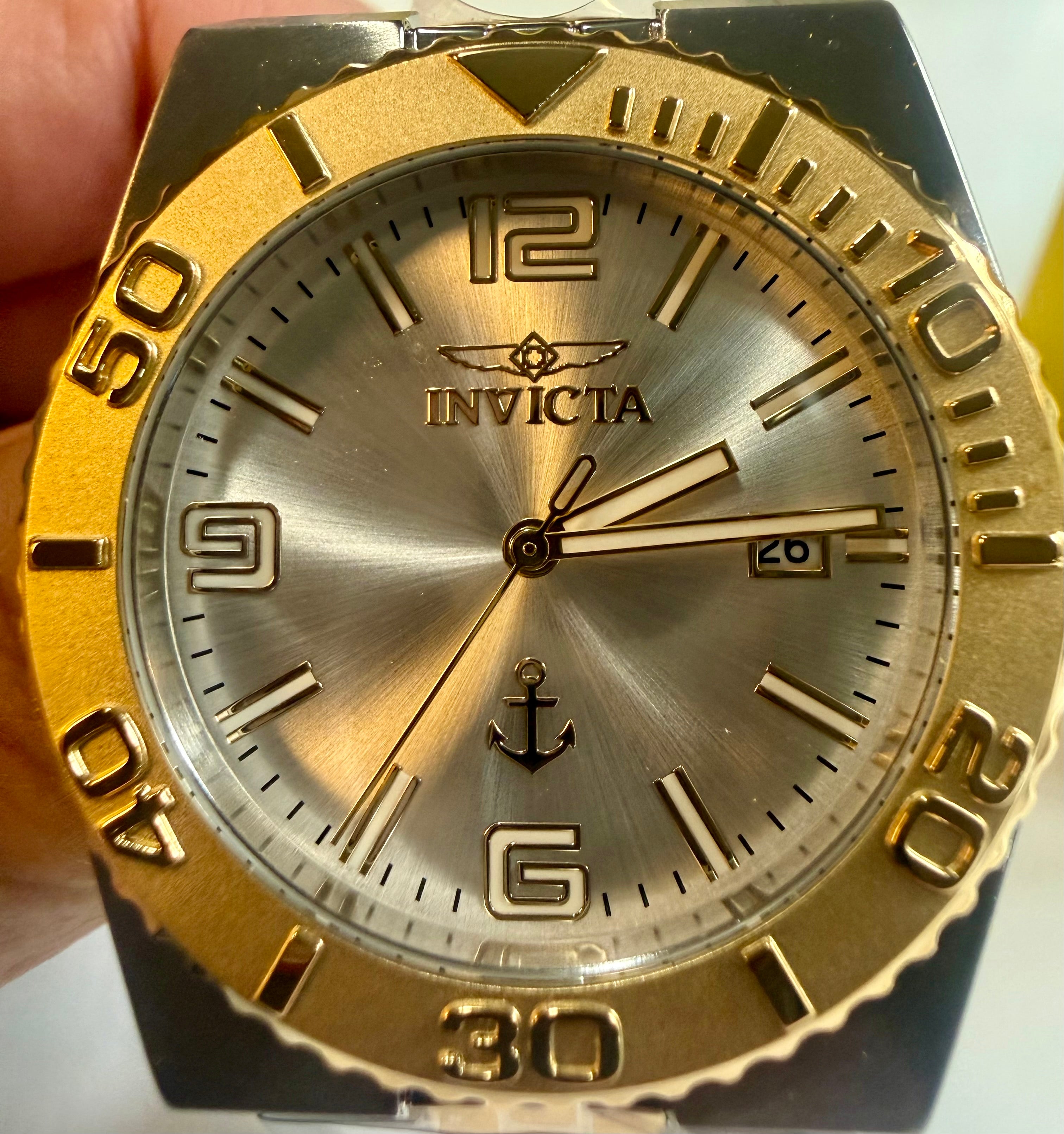 Invicta Ocean Voyage 38mm Pro Diver Gold  watch with silver face held by a hand