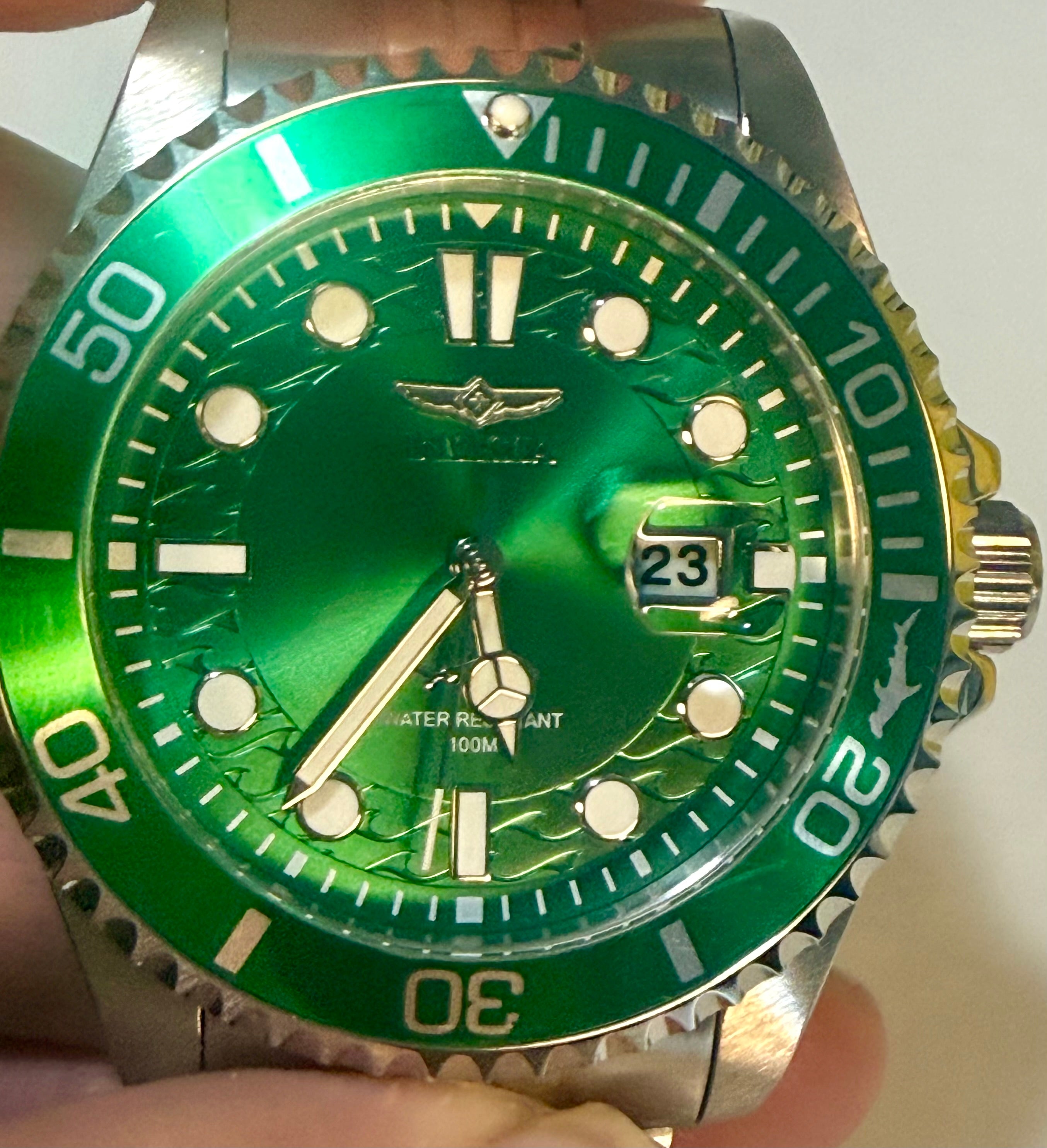 Invicta Mens Pro Diver 43mm Green wristwatch with a detailed face held by a hand on a light background