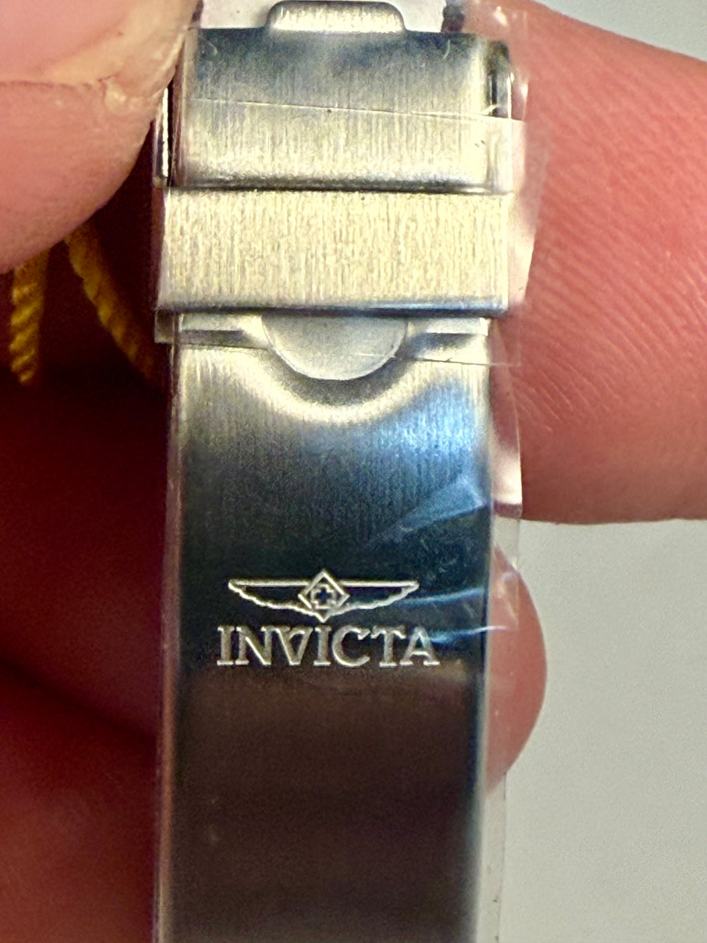 Ladies Invicta Pro Diver 24.5 mm watch band clasp held between fingers