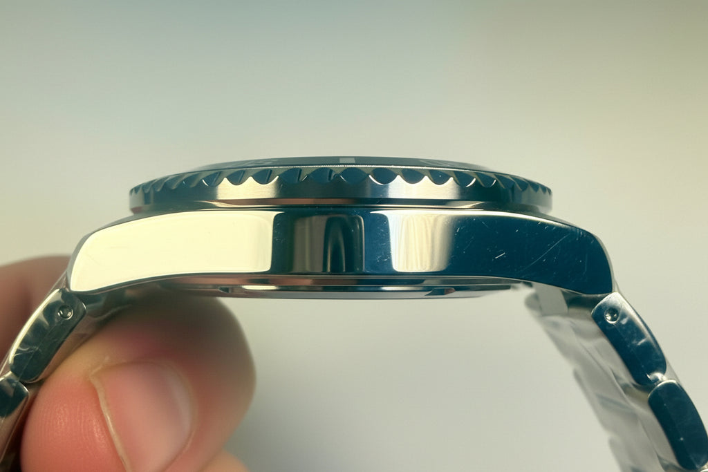Close-up of an Invicta Specialty Rowan  silver watch case held by a hand against a light background