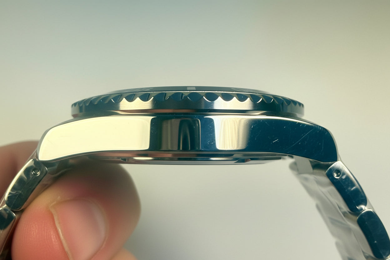 Close-up of an Invicta Specialty Rowan  silver watch case held by a hand against a light background