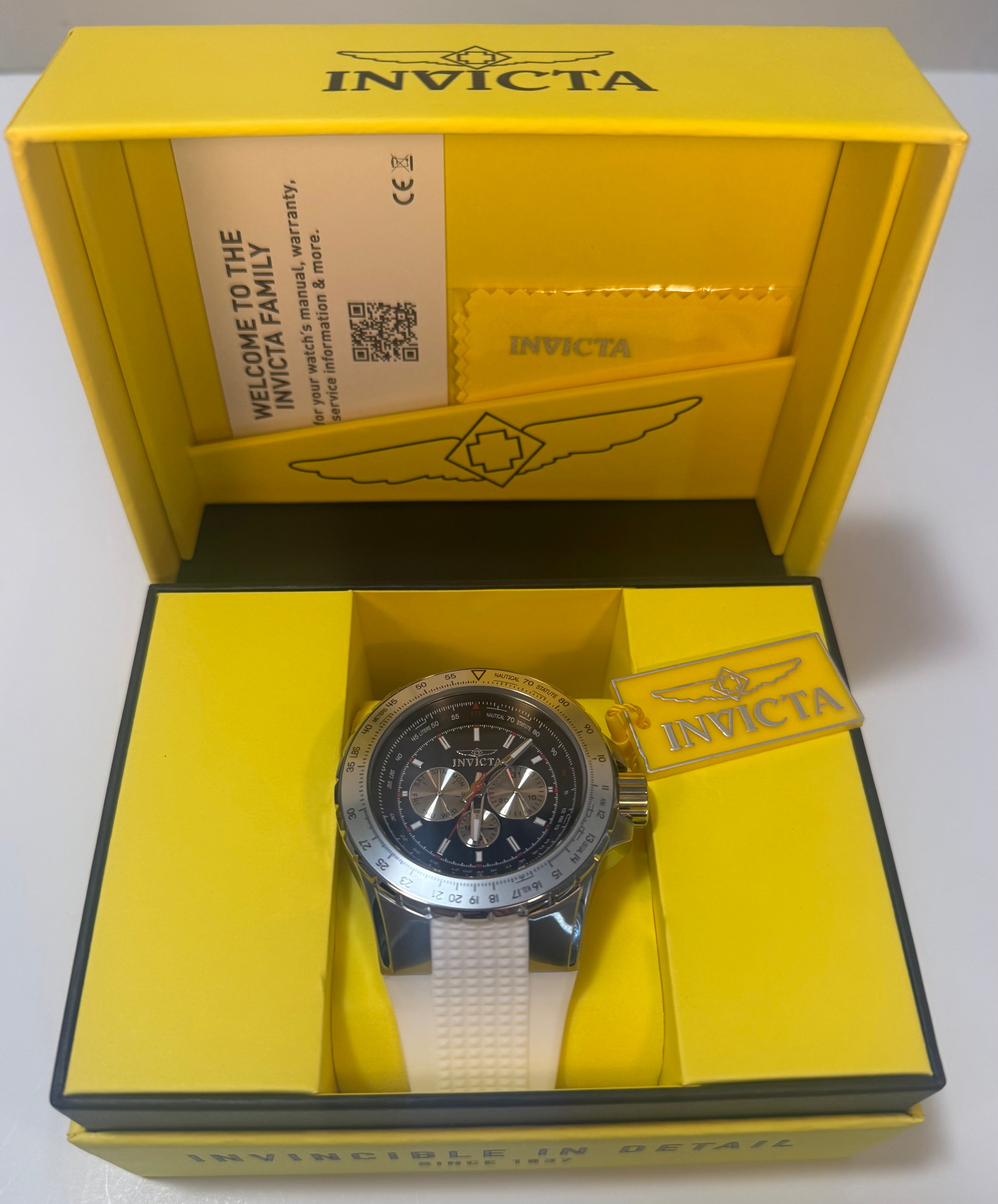 Invicta Aviator  Mens White Silicone Chronograph 50mm Watch in a yellow box on a white background