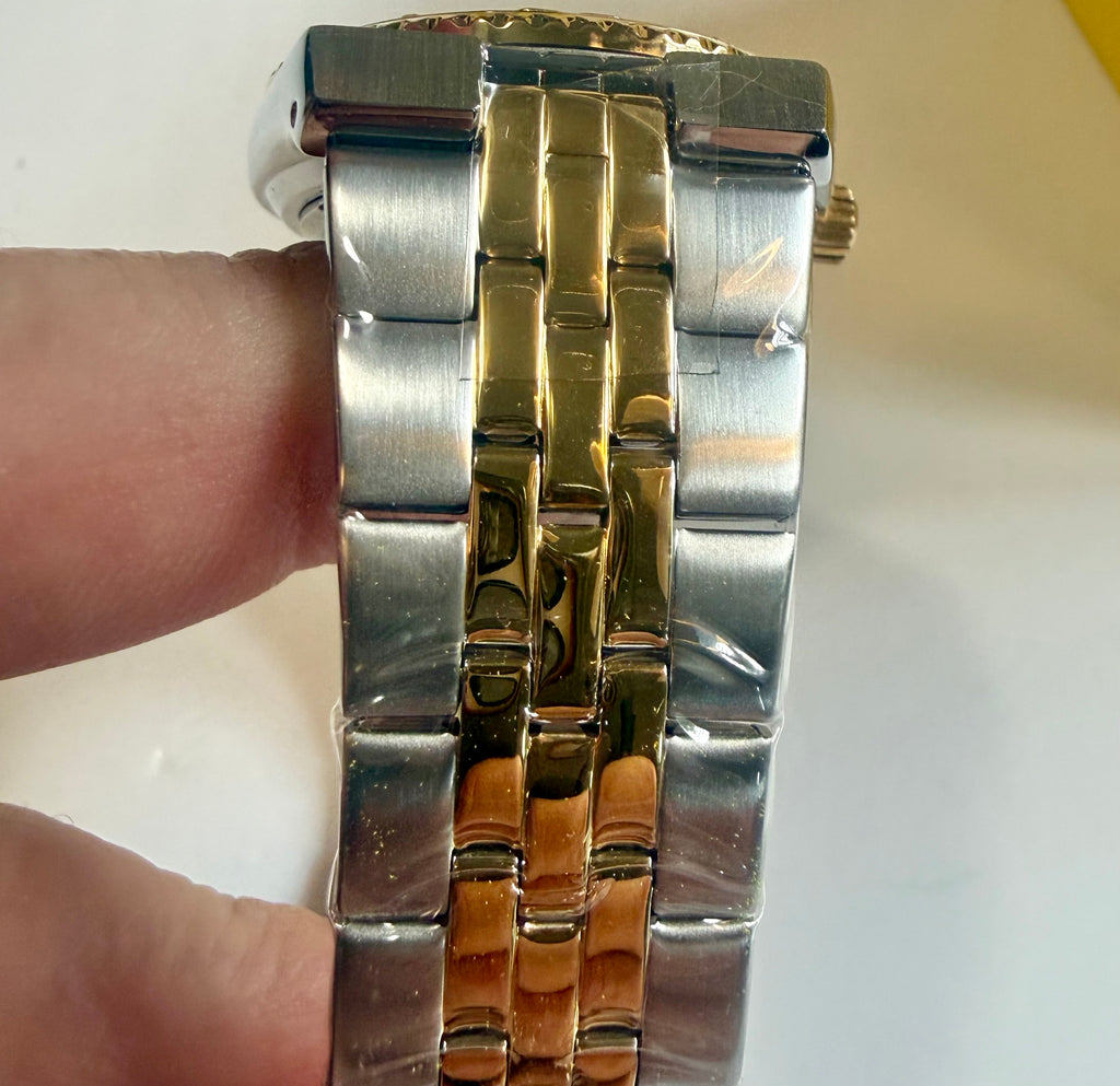 Close-up of a Invicta Ocean Voyage 38mm Pro Diver silver and gold watch band on a white background