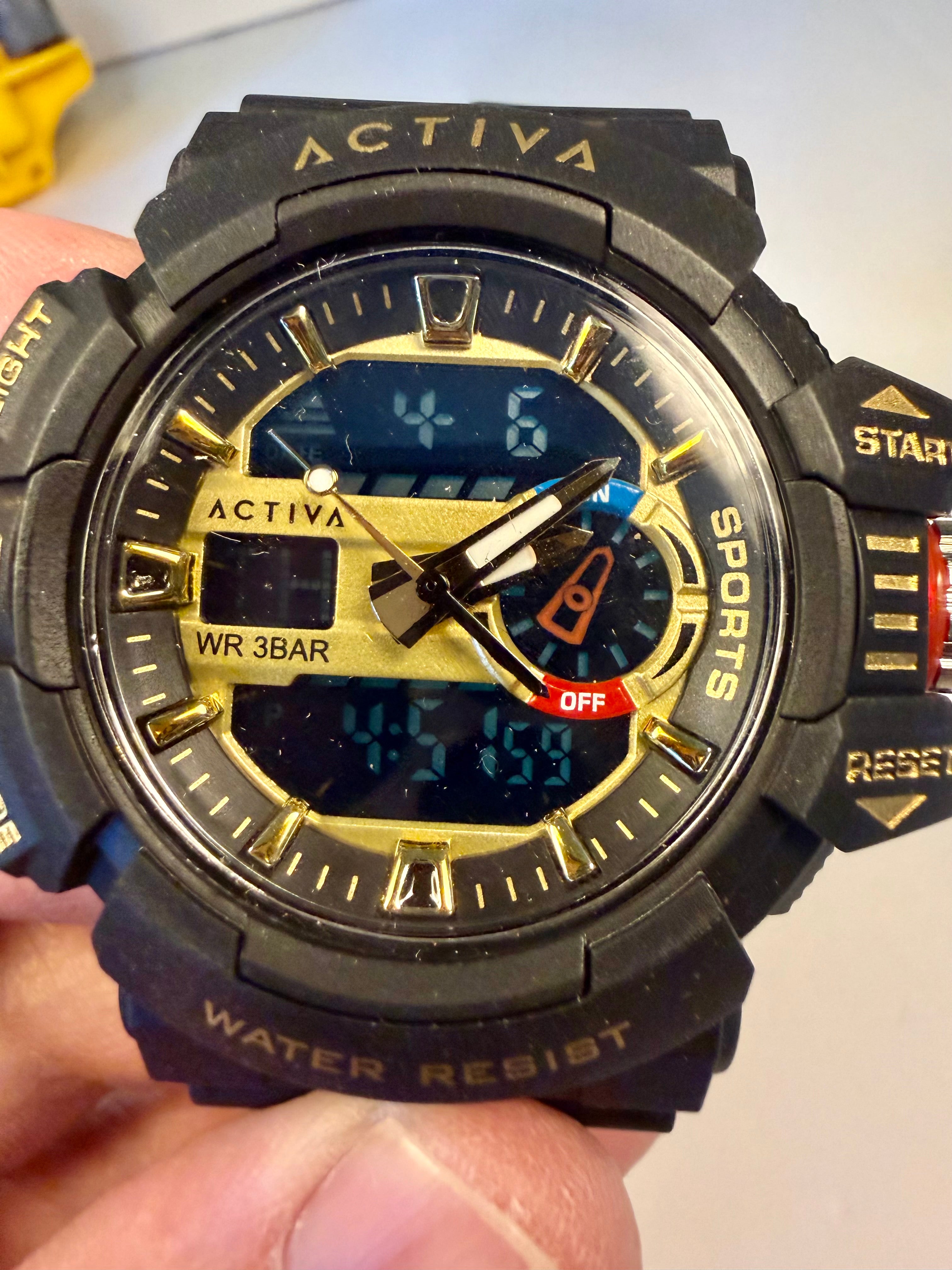 Invicta Activa Vord X watch held in a hand with a blurred background