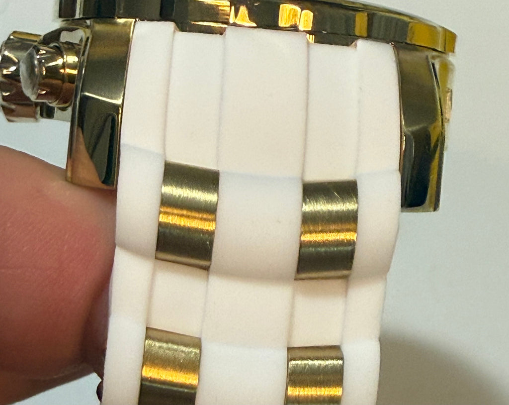 Gold and white band on a wrist against a white background