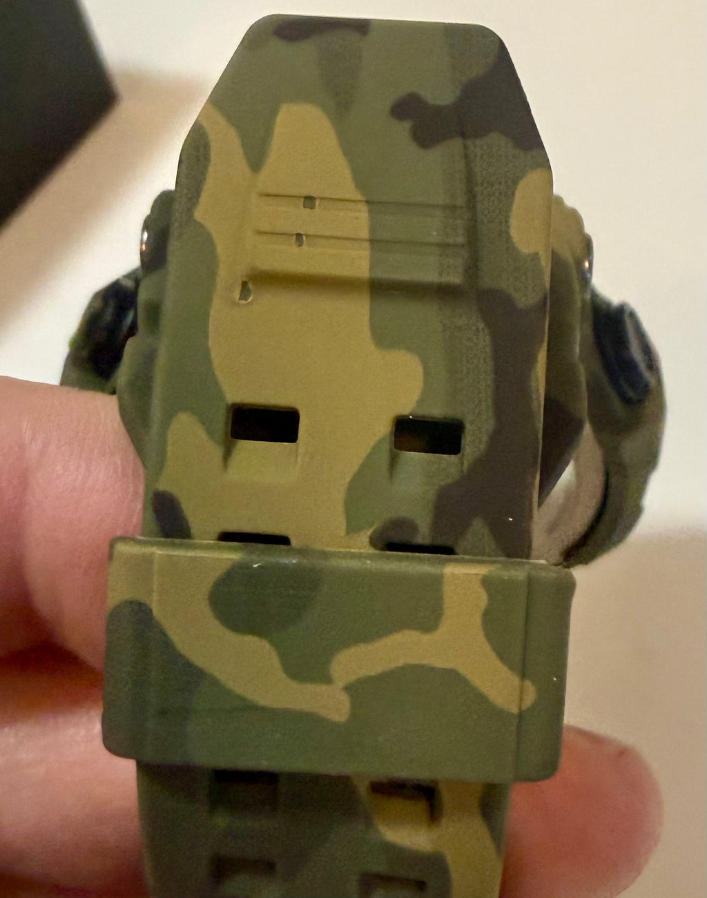Activa X Black Ops 52mm Camouflage digital watch band held by a hand against a neutral background