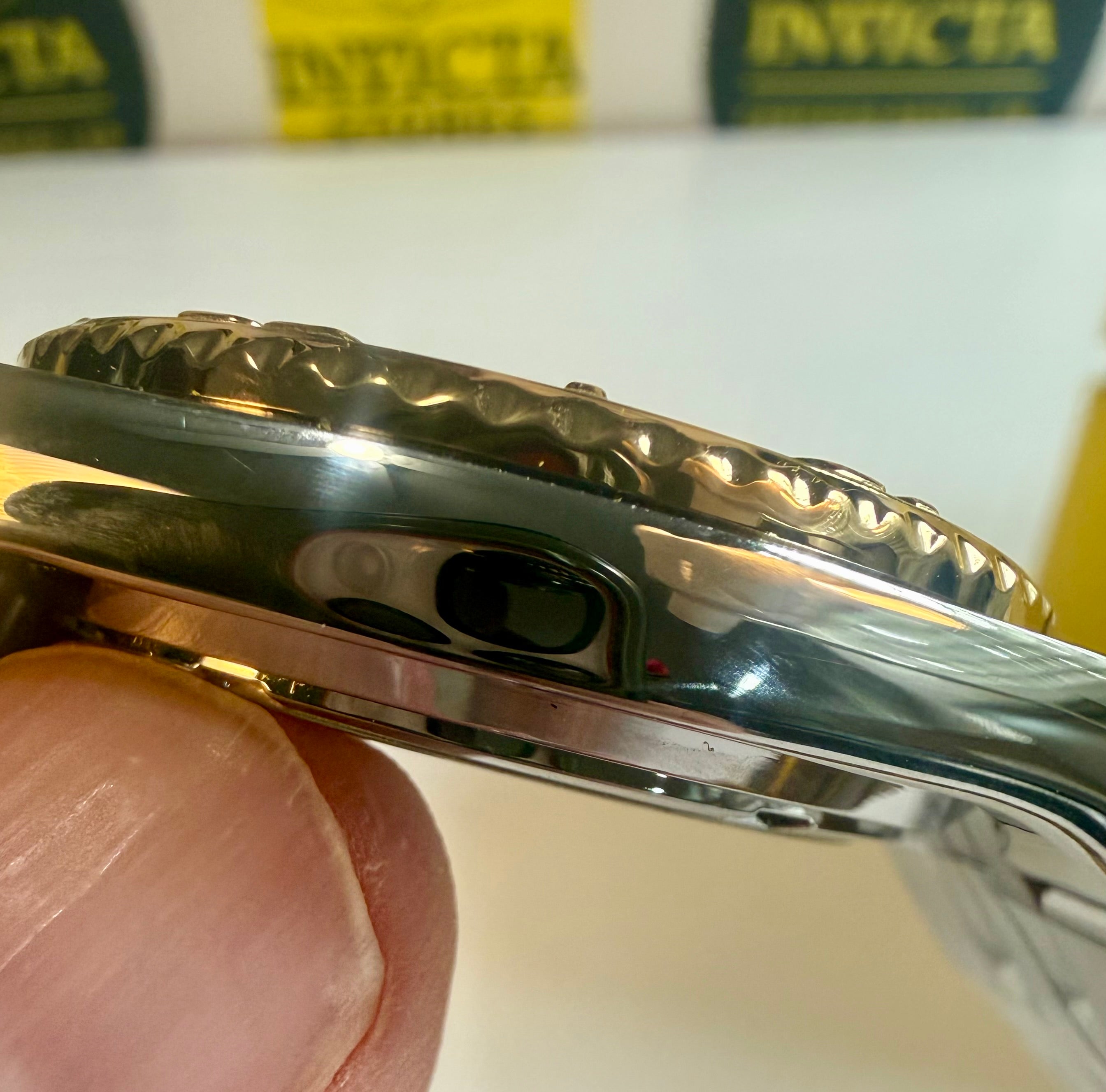 Close-up of a Invicta Ocean Voyage 38mm Pro Diver watch case with 'Invicta' branding in the background.
