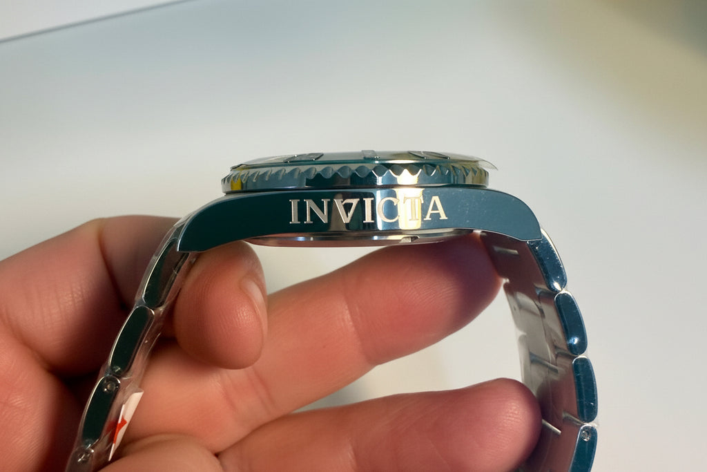 Invicta Pro Diver 12819 Swiss Ronda 515 40mm 0.06ctw Diamond watch band held by a hand with a blurred background