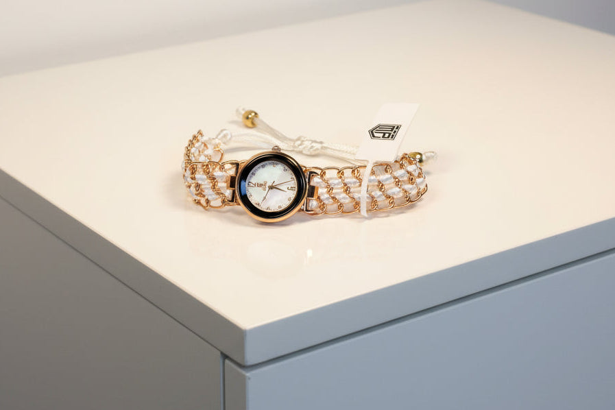 Ladies Montres Prestige Gold chain watch with a watch face on a beige background