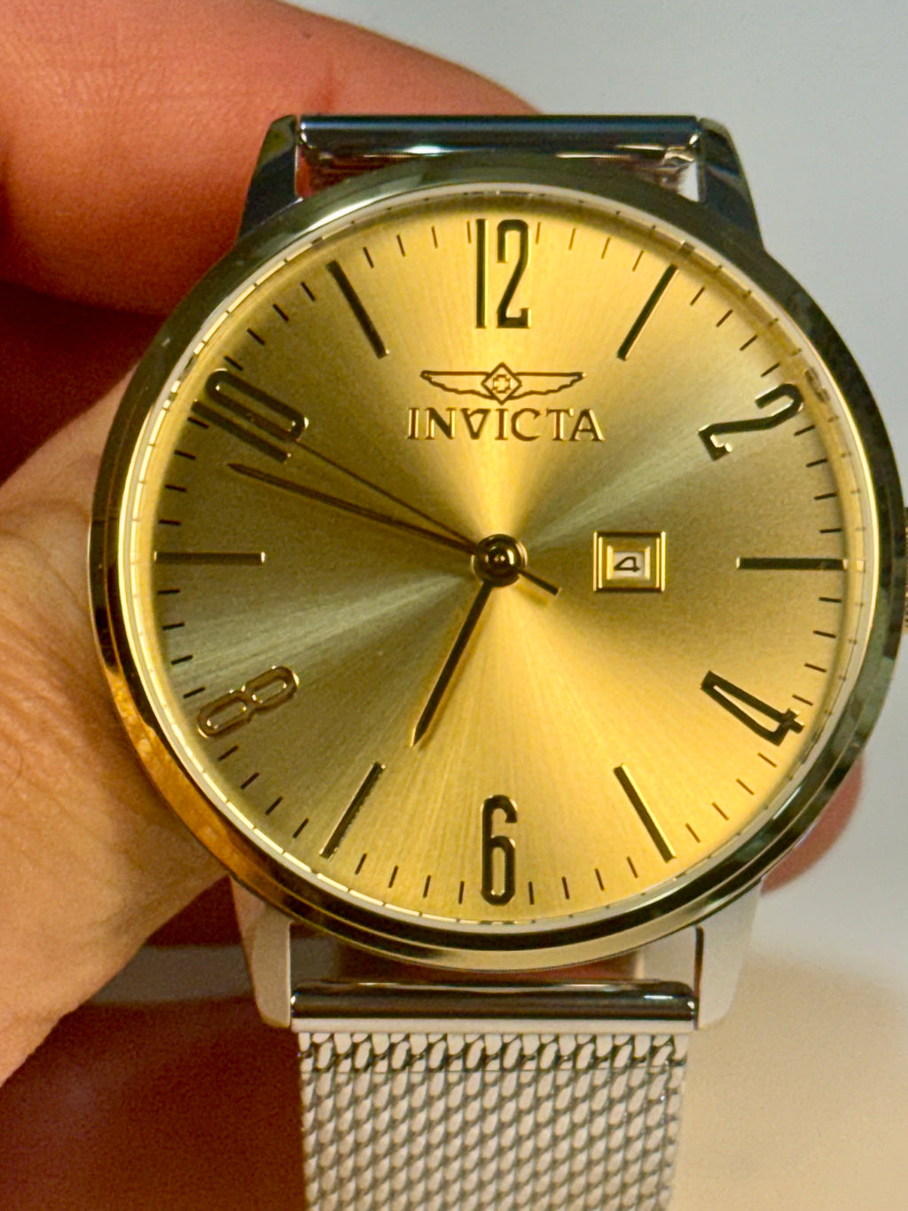 Invicta Mens Specialty watch held by a hand against a white background