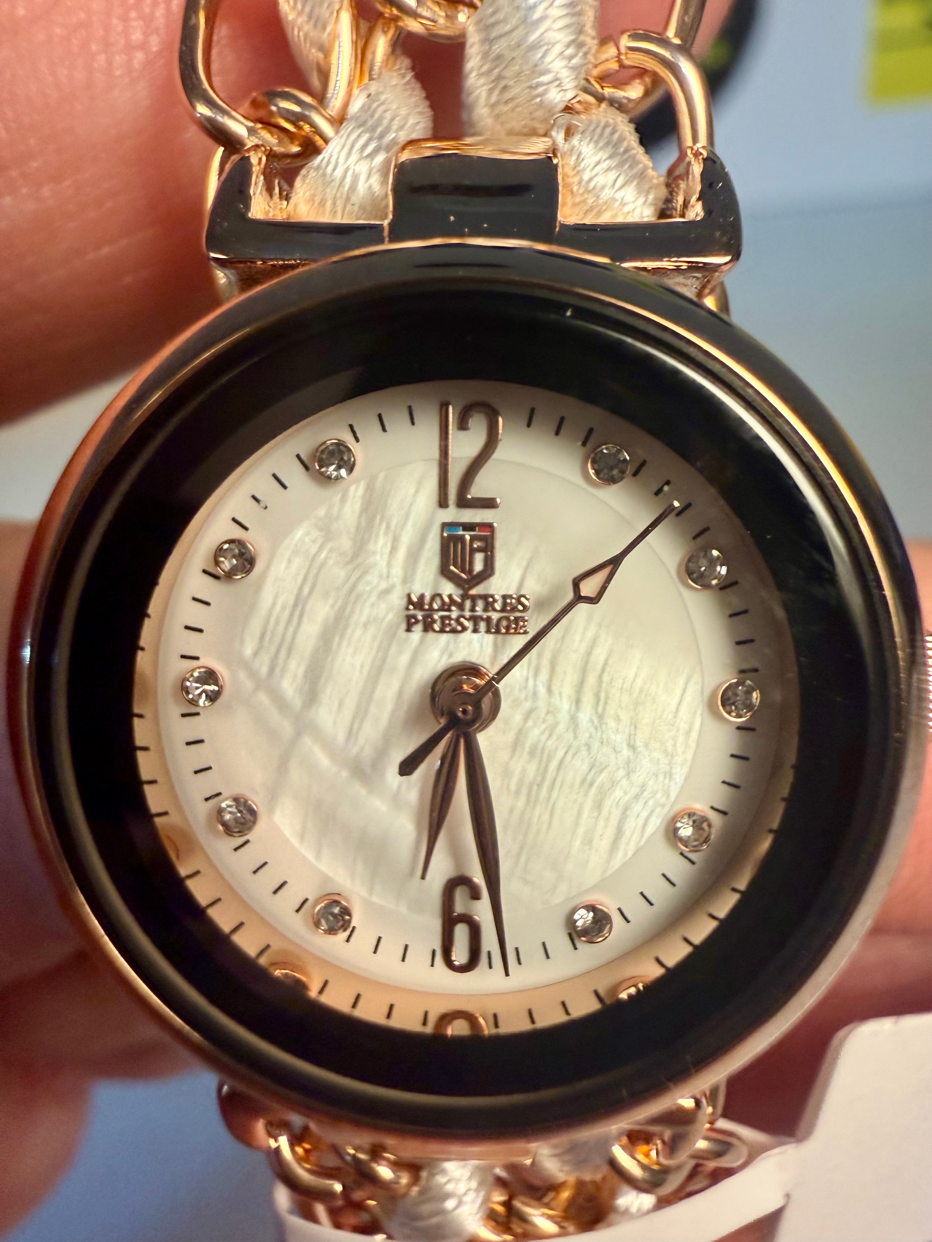 Ladies Montres Prestige wristwatch with a white face held by a hand