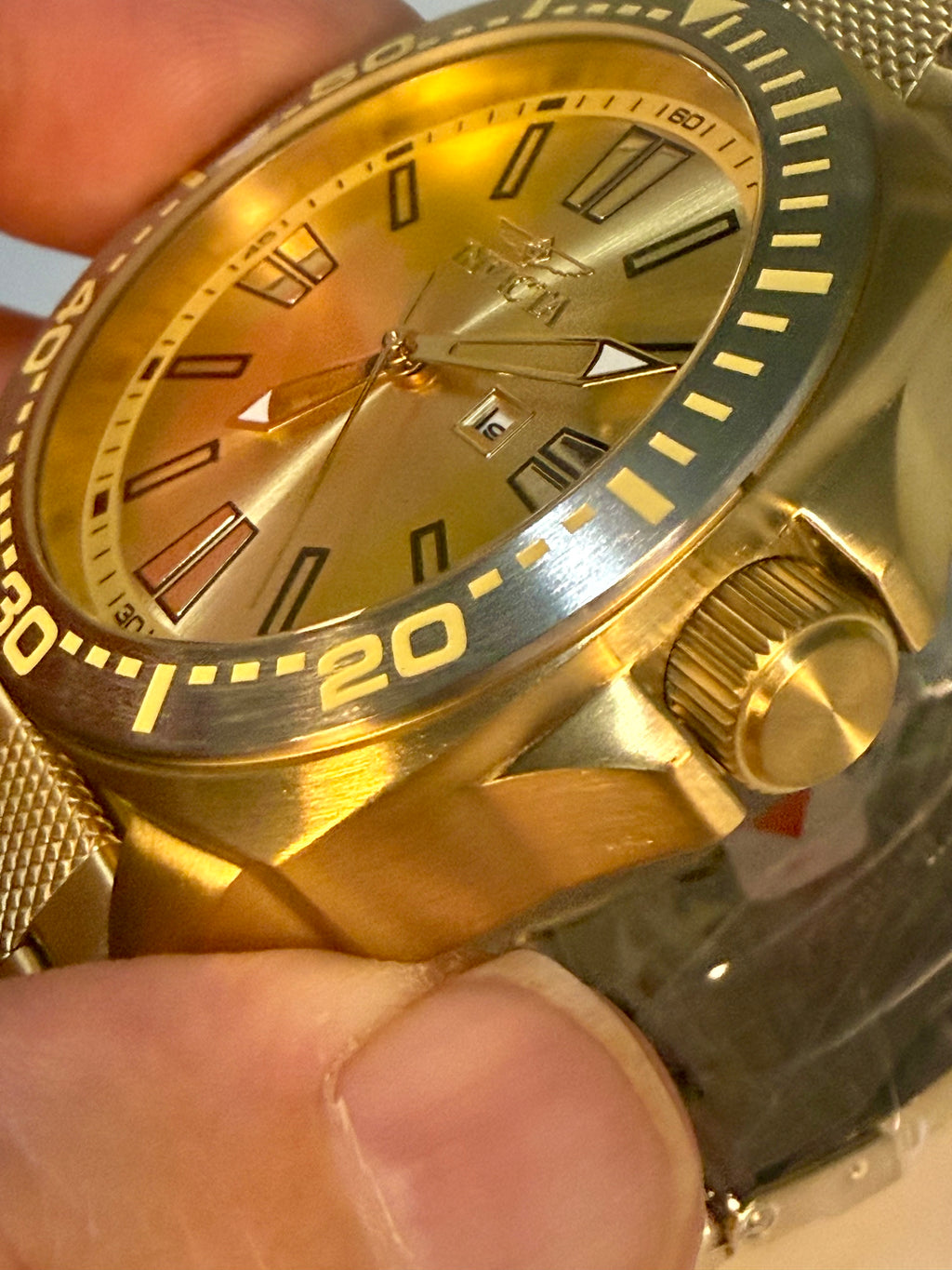 Invicta Speedway 48mm Gold watch with detailed face held by a hand