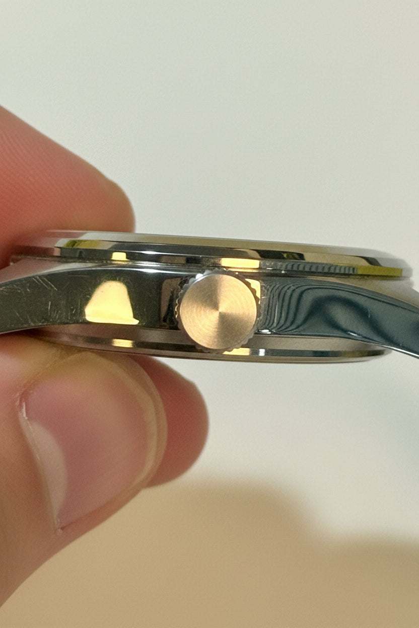 Close-up of a Invicta Ocean Voyage 41mm  held between fingers with a plain background