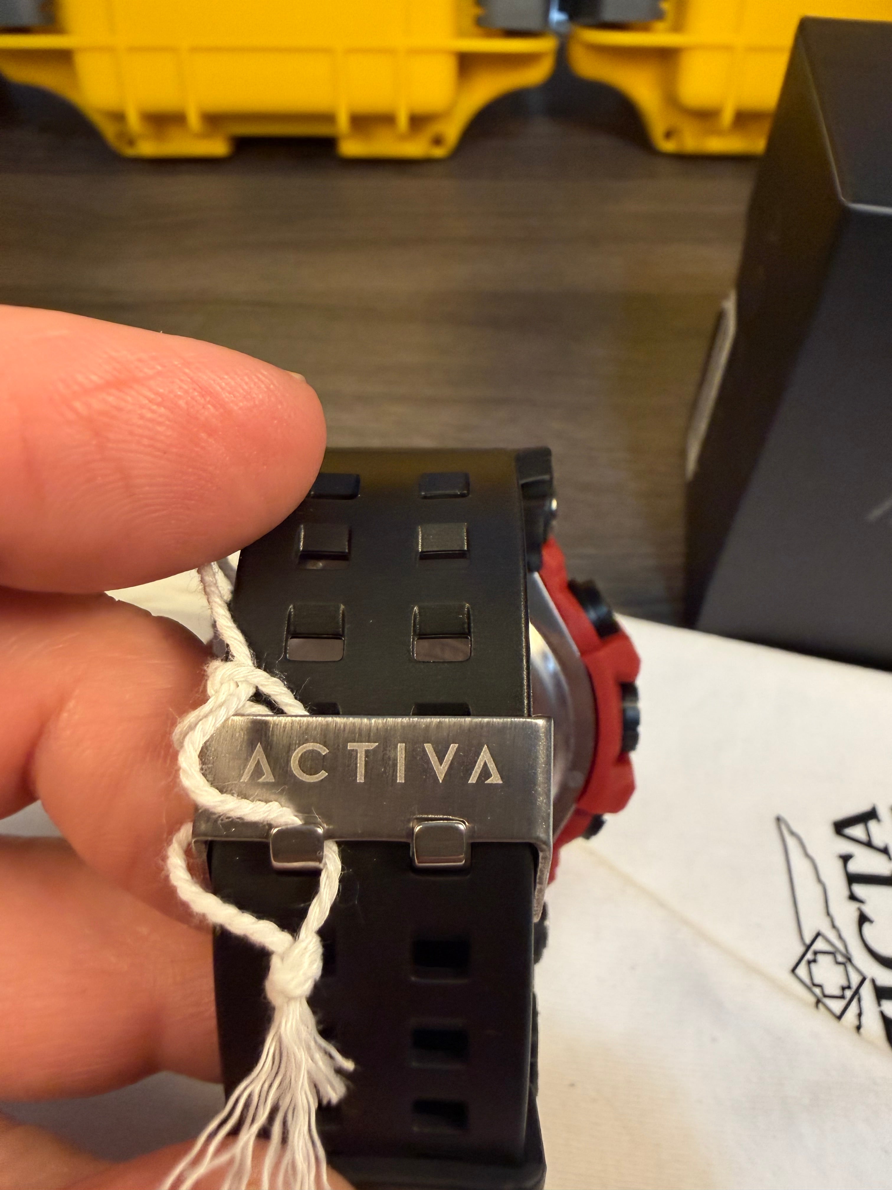 Close-up of an activa wristwatch buckle with a visible activa brand name etched on it. held by a hand.