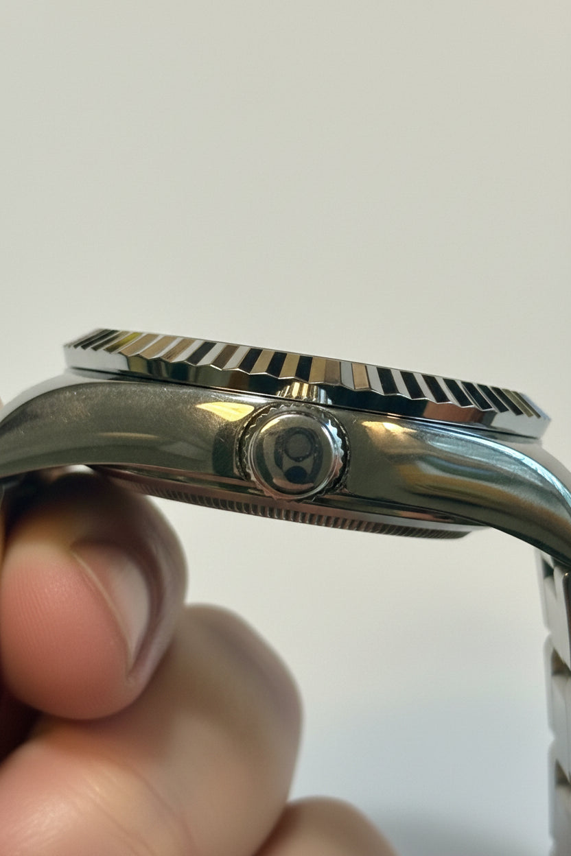 Close-up of aLadies Specialty Windsor 36mmh band held by a hand against a neutral background