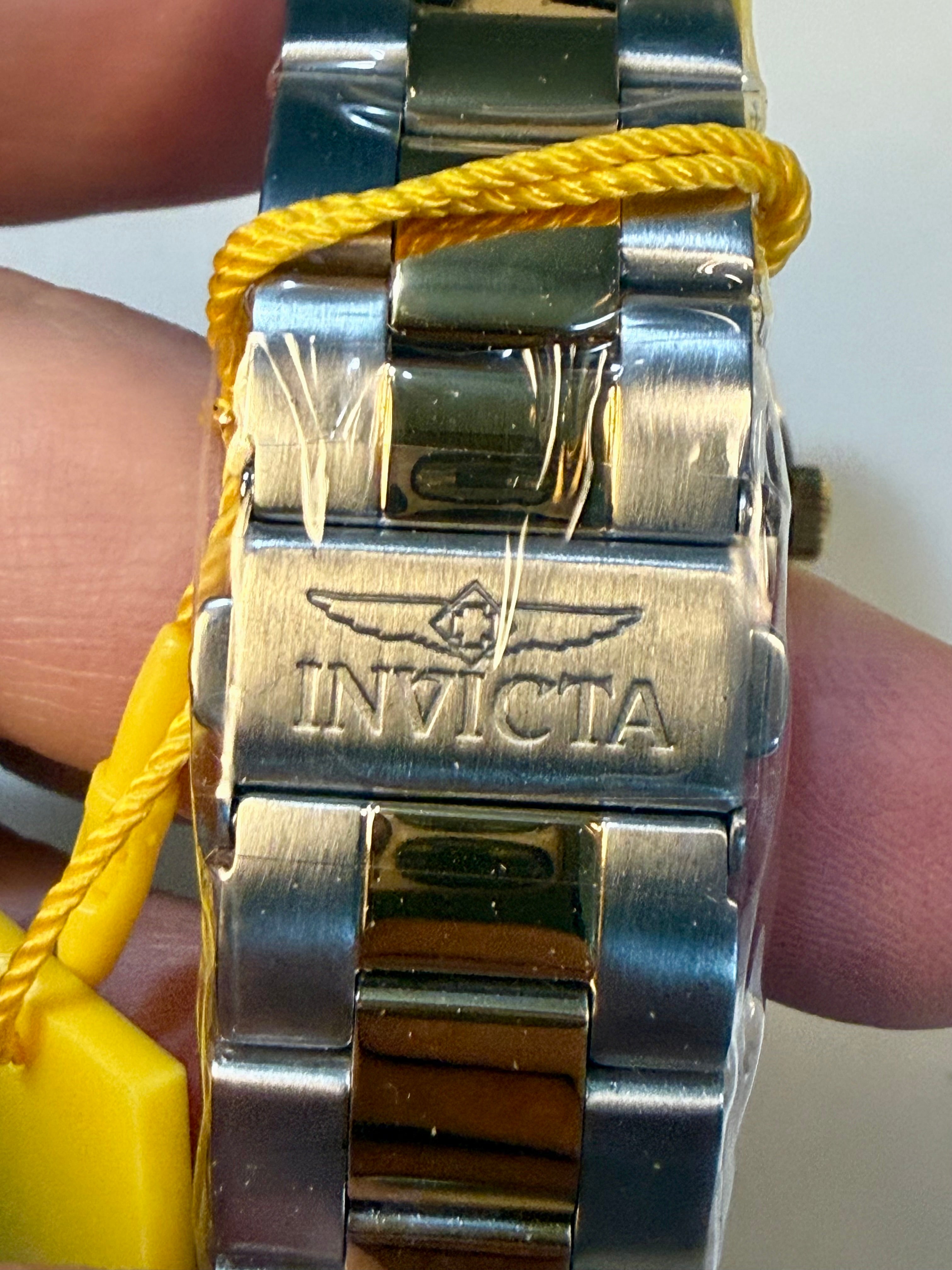 Close-up of a Invicta Mens Specialty Belmont 43mm silver Invicta watch with a yellow strap held between fingers.