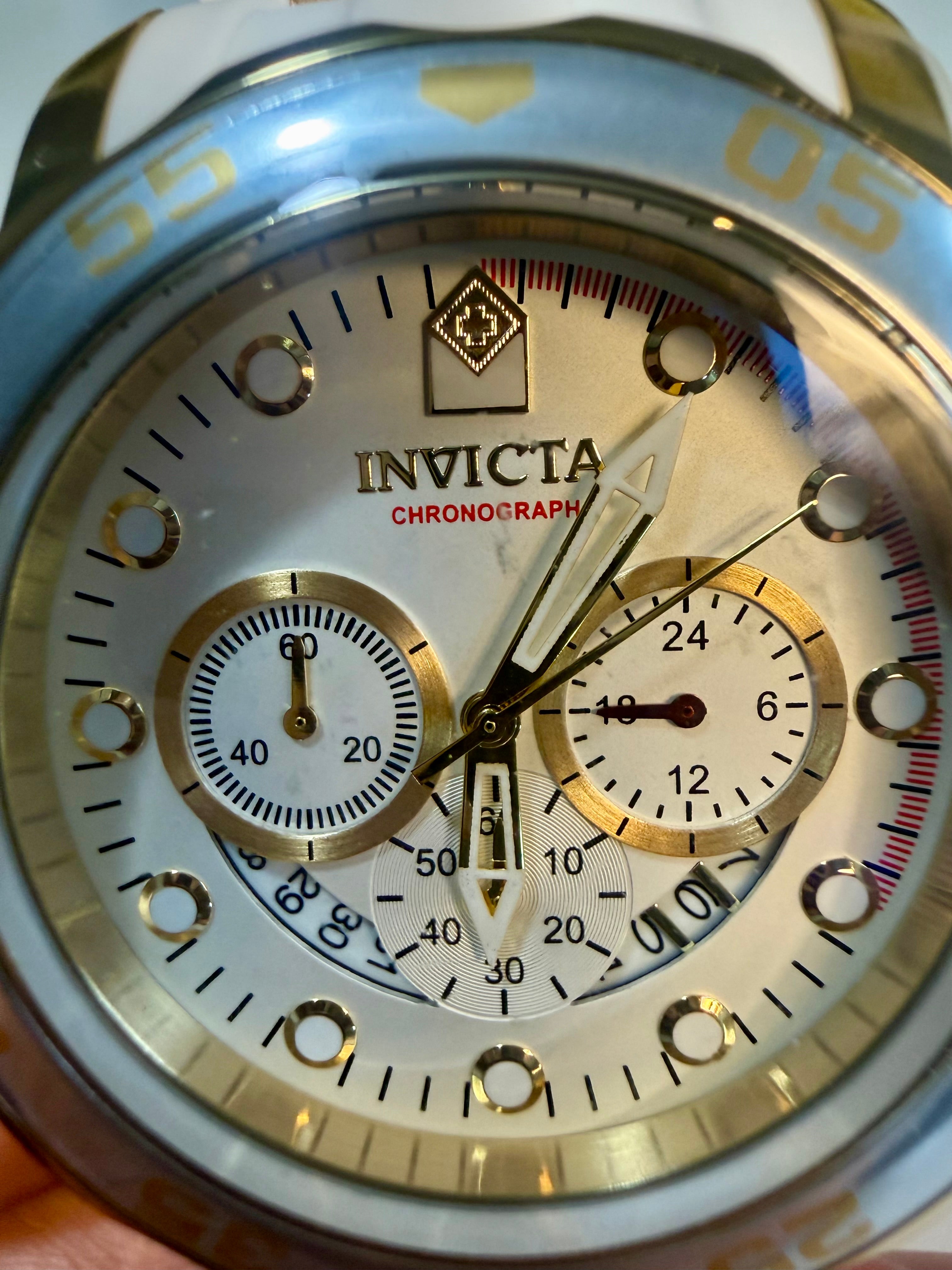 Invicta Scuba 48mm watch with gold and silver accents held by a hand