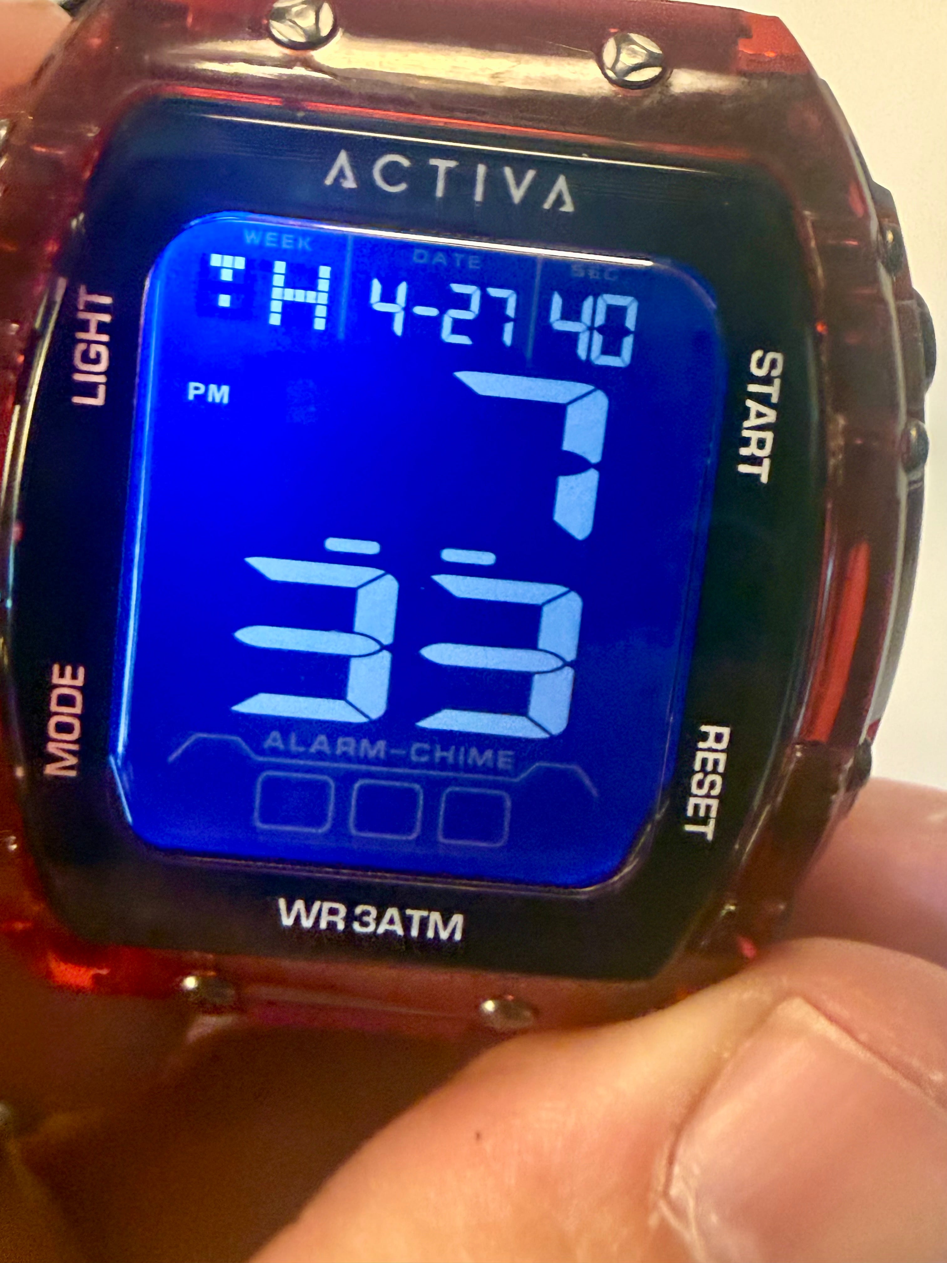 Activa X Ranger Bundle Digital watch with blue screen displaying time and date, held by a person.