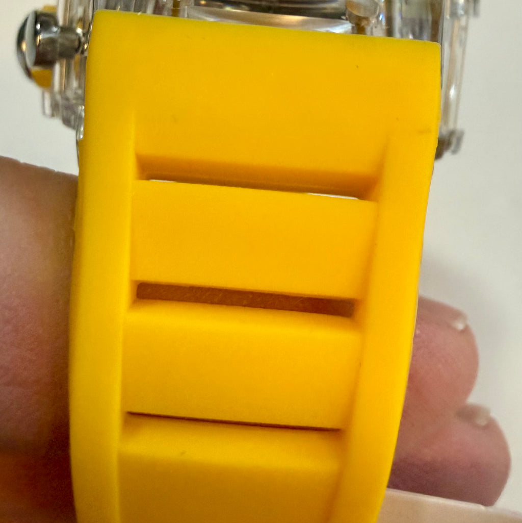 Close-up of a yellow watch strap on a wrist with a blurred background