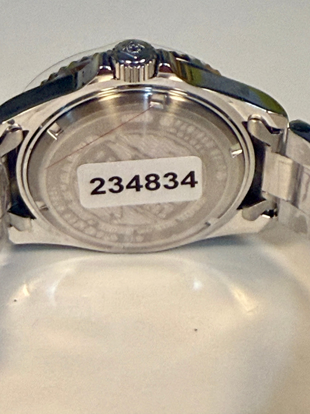 Invicta Pro Diver 12819 Swiss Ronda 515 40mm 0.06ctw Diamond Back view of a silver watch with a visible serial number on a light gray background