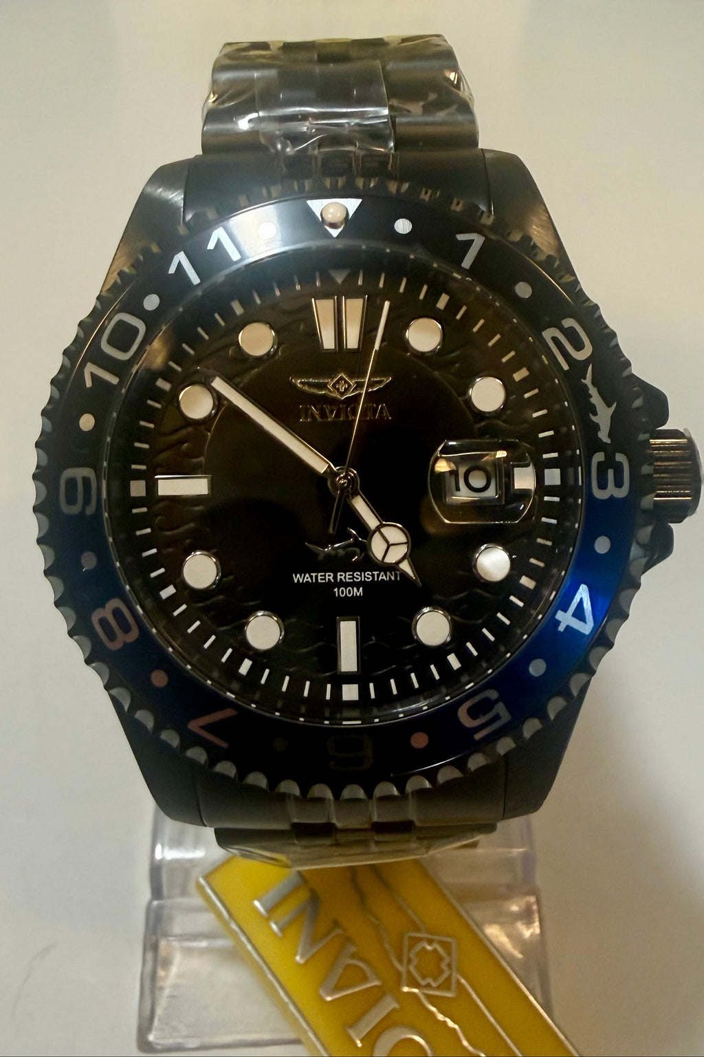 Invicta watch on a stand with a white background